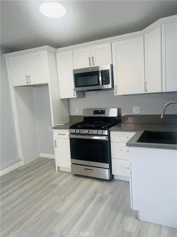 a kitchen with granite countertop a stove and a sink