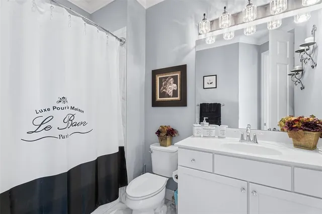 a bathroom with a sink mirror vanity and toilet