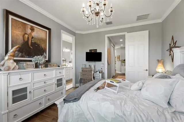 a bedroom with a large bed and a flat tv screen on dresser