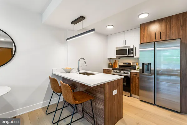 a kitchen with a sink a refrigerator and a stove top oven