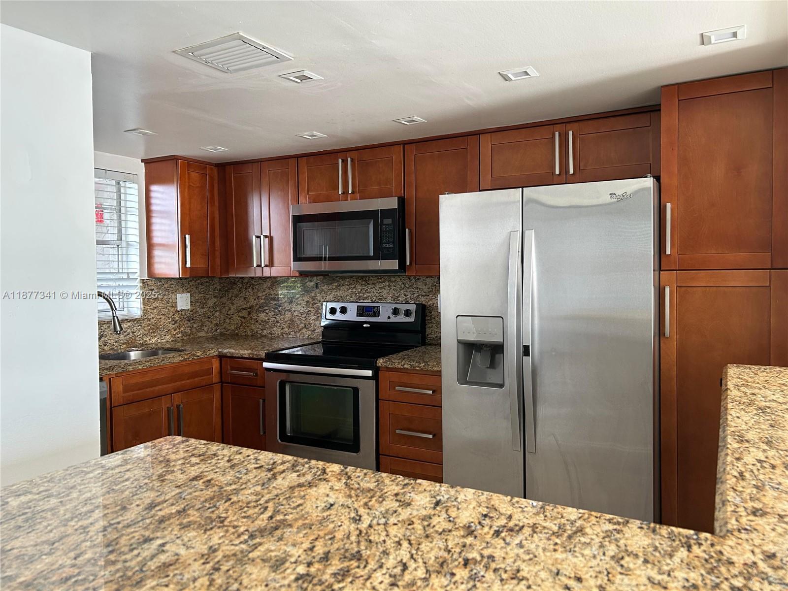 3100 West Rolling Hills Circle, Unit 702 Davie, FL 33328 - Photo 11 of 16 a kitchen with stainless steel appliances granite countertop a refrigerator stove and a sink