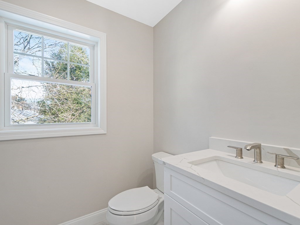 33 Circle Drive Waltham, MA 02452 - Photo 34 of 42 a bathroom with a granite countertop toilet a sink a mirror and a window