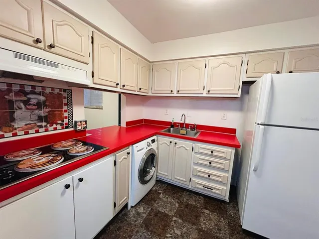 a kitchen with white cabinets and white appliances
