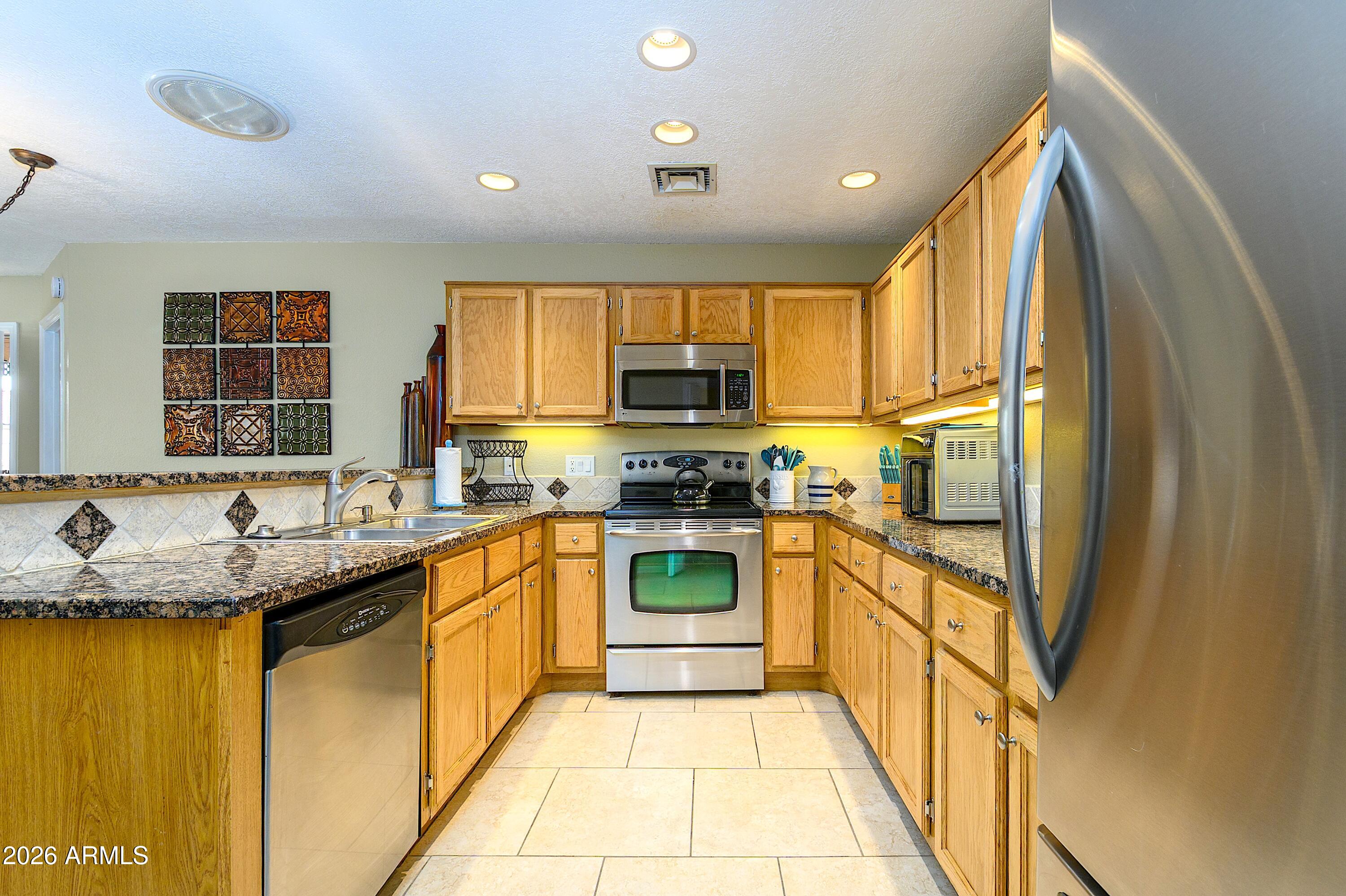 14300 West Bell Road, Unit 420 Surprise, AZ 85374 - Photo 12 of 27 a kitchen with stainless steel appliances granite countertop a sink and a stove