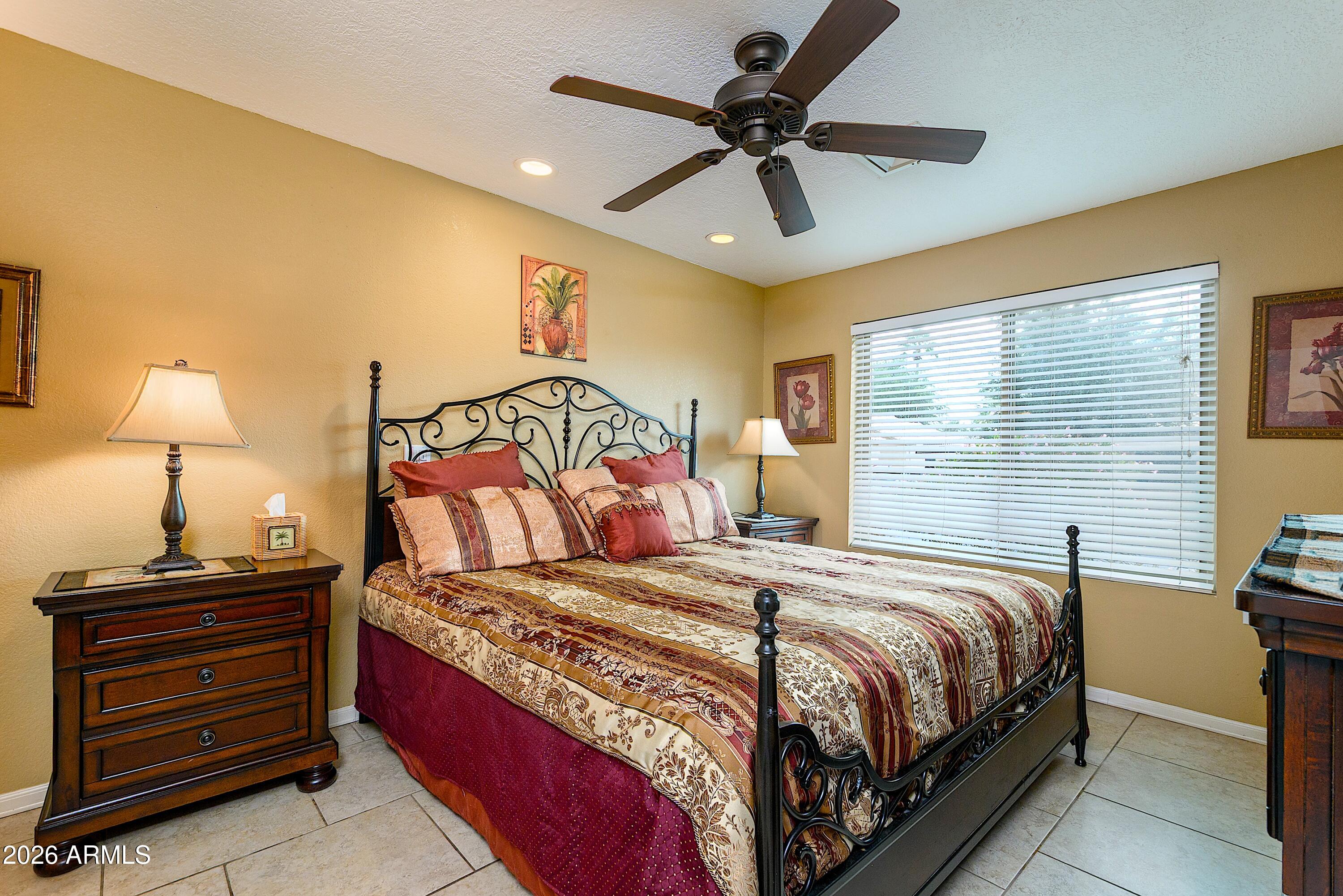 14300 West Bell Road, Unit 420 Surprise, AZ 85374 - Photo 13 of 27 a bedroom with a bed and a chandelier