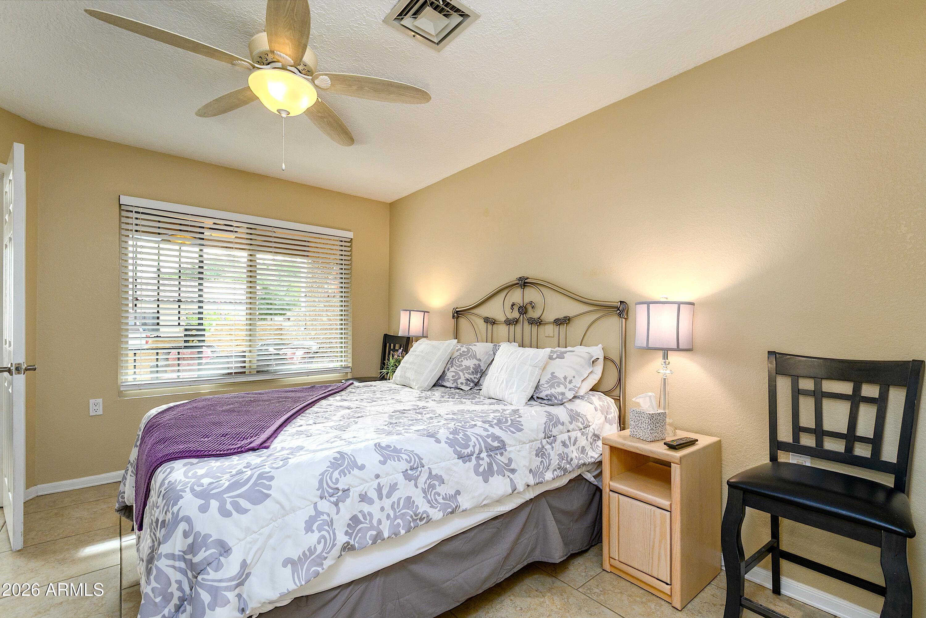 14300 West Bell Road, Unit 420 Surprise, AZ 85374 - Photo 20 of 27 a bedroom with a bed and a chandelier