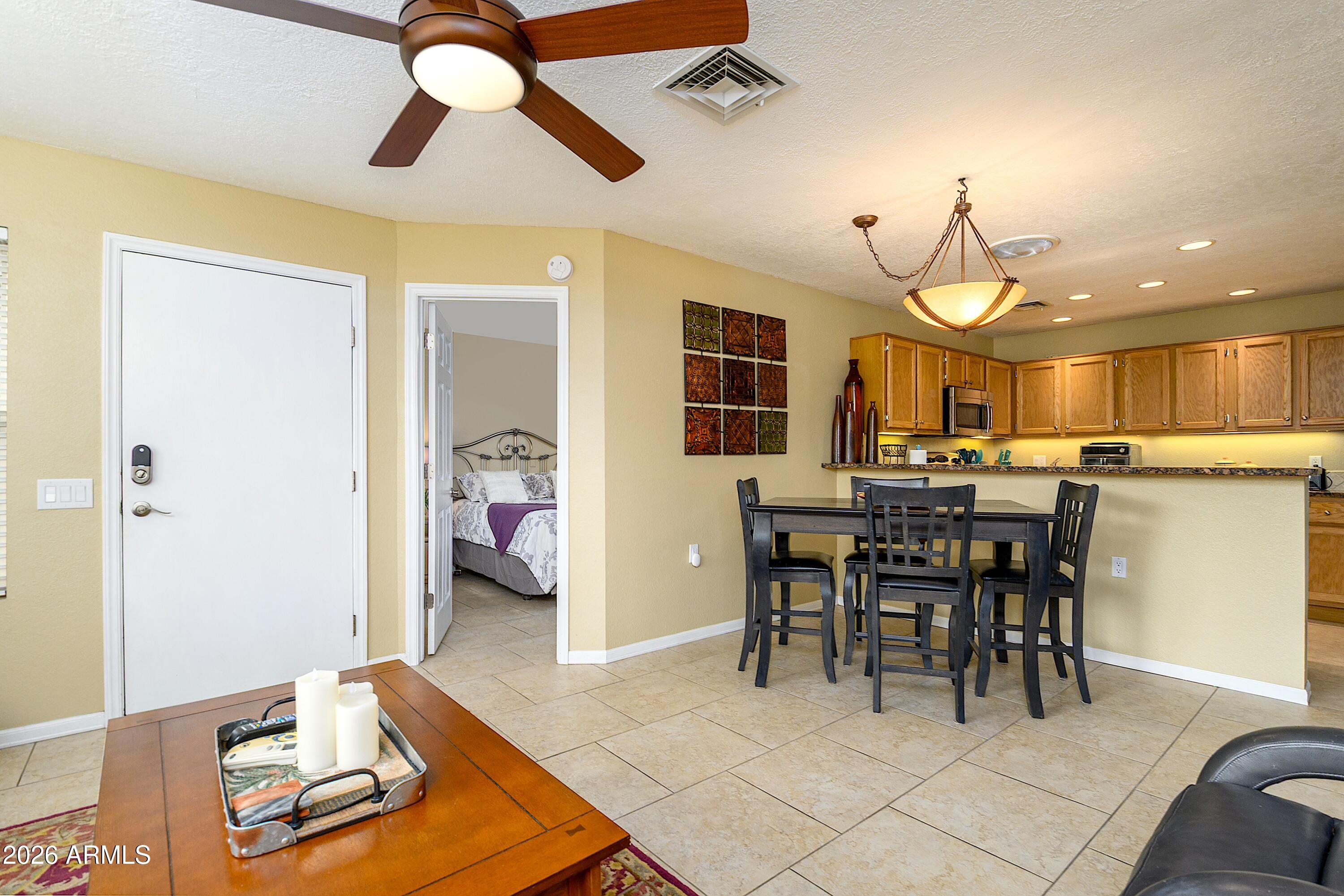 14300 West Bell Road, Unit 420 Surprise, AZ 85374 - Photo 8 of 27 a view of a dining room with furniture and a chandelier fan