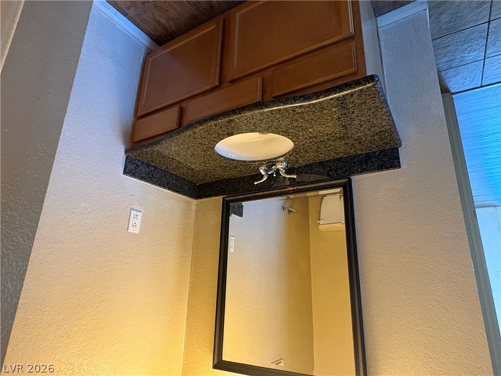 9325 West Desert Inn Road, Unit 123 Las Vegas, NV 89117 - Photo 12 of 36 A dark granite vanity with an undermount sink offers both style and convenience in this bathroom.
