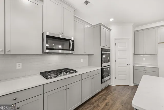 a close view of a stove and microwave in a white cabinet