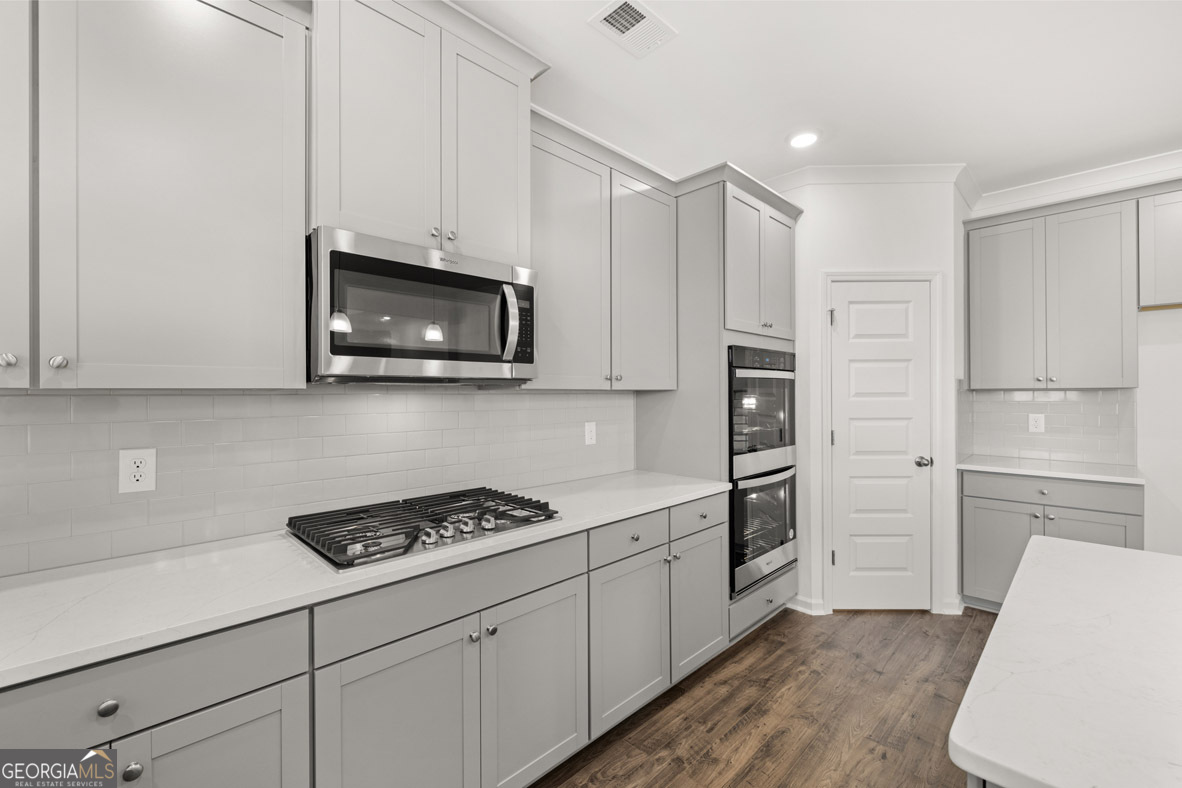 400 Hazel Drive Locust Grove, GA 30248 - Photo 18 of 50 a kitchen with stainless steel appliances white cabinets and a stove top oven