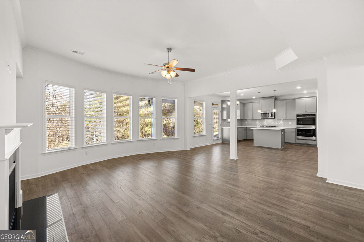 400 Hazel Drive Locust Grove, GA 30248 - Photo 21 of 50 a view of an empty room with wooden floor and a kitchen