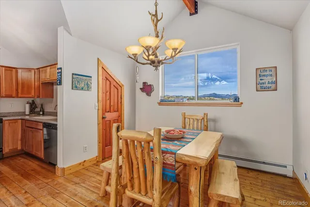a dining room with stainless steel appliances wooden floor dining table and chairs