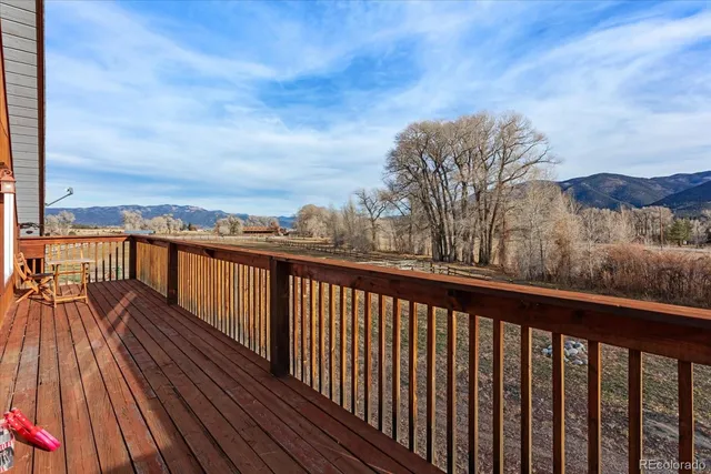 a balcony with wooden floor and city view