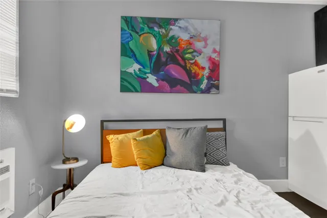 a bedroom with a bed and painting on the wall