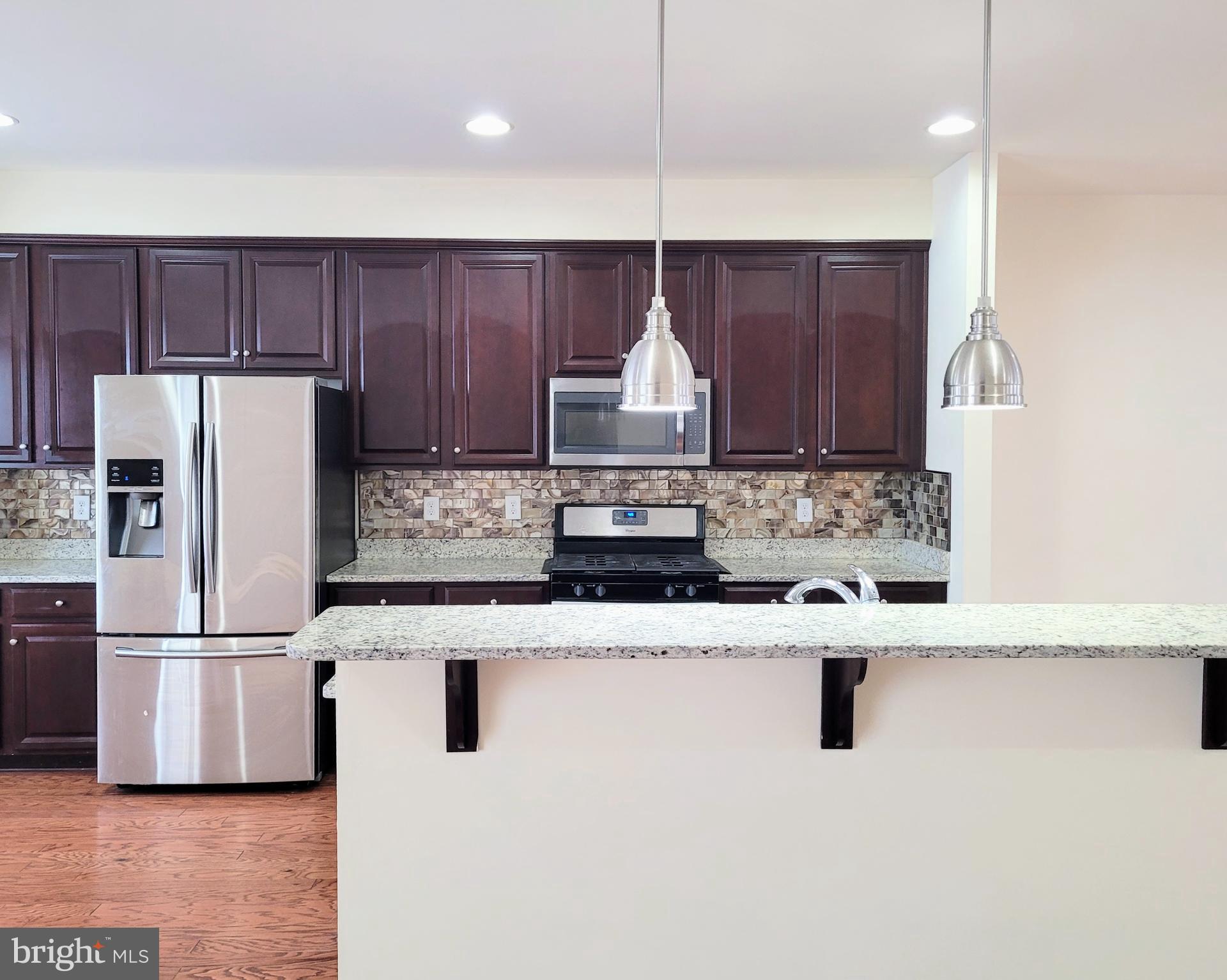 628 Rigel Way Bear, DE 19701 - Photo 4 of 20 a kitchen with kitchen island stainless steel appliances a sink and a refrigerator