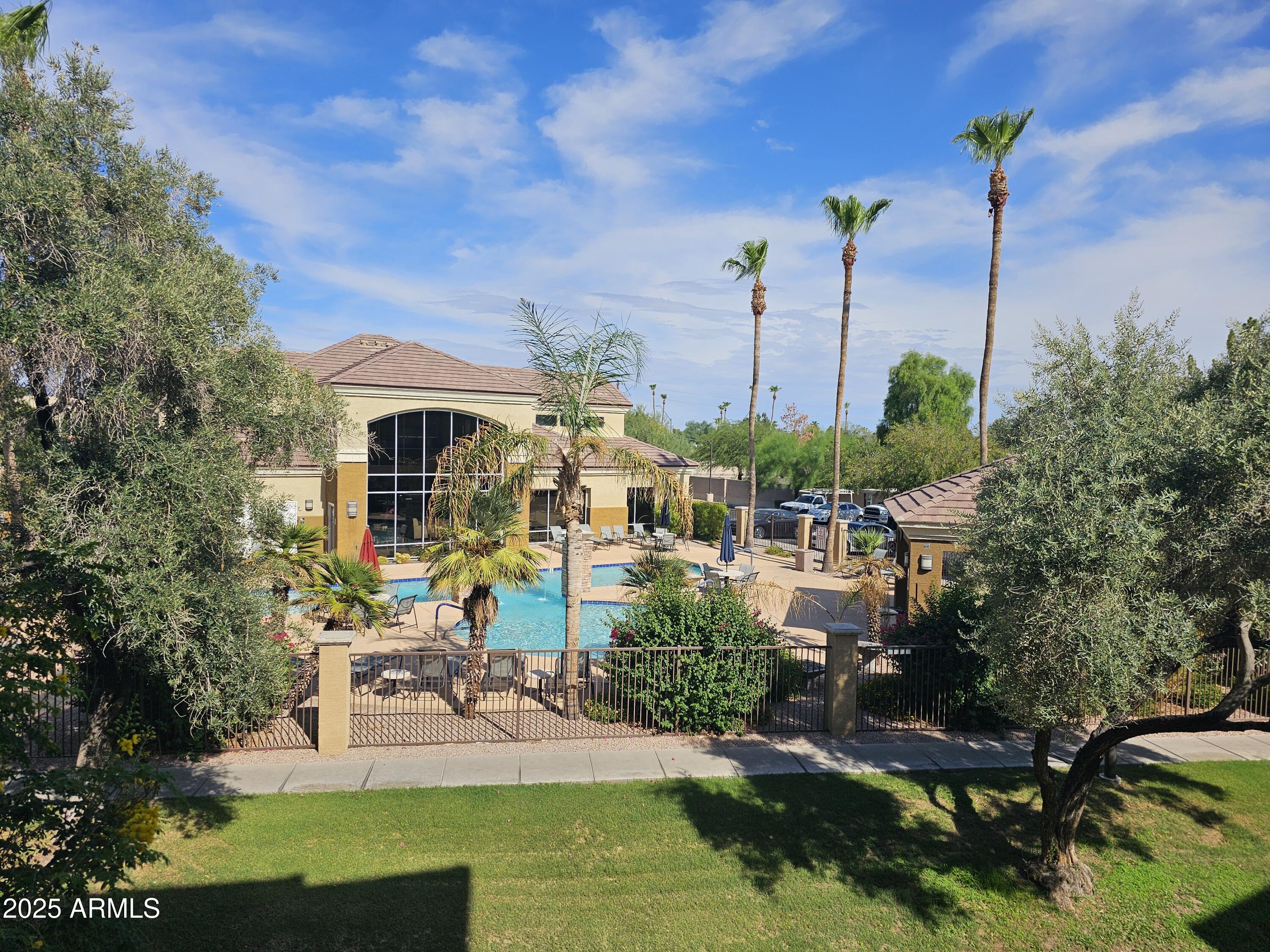 18416 North Cave Creek Road, Unit 2013 Phoenix, AZ 85032 - Photo 11 of 17 a view of a white house with a big yard and potted plants