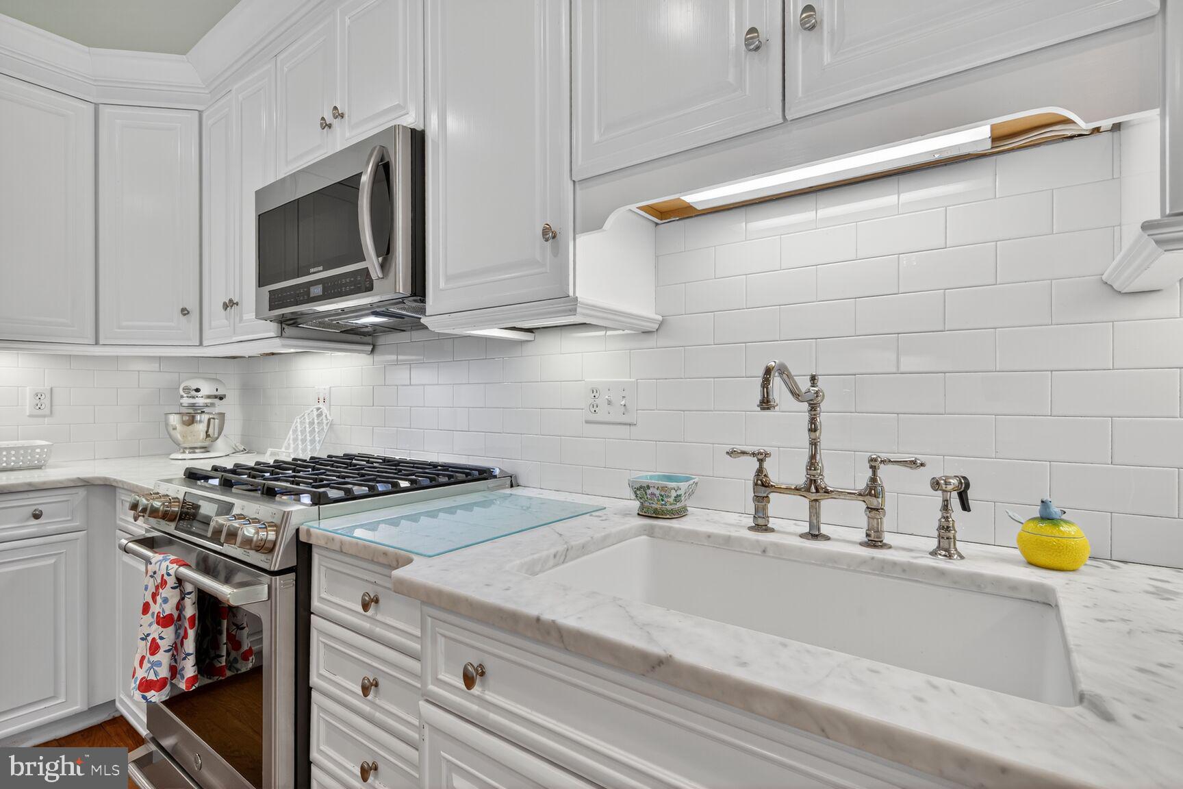 7200 Helmsdale Road Bethesda, MD 20817 - Photo 21 of 50 a kitchen with stainless steel appliances granite countertop a sink a stove and wooden cabinets