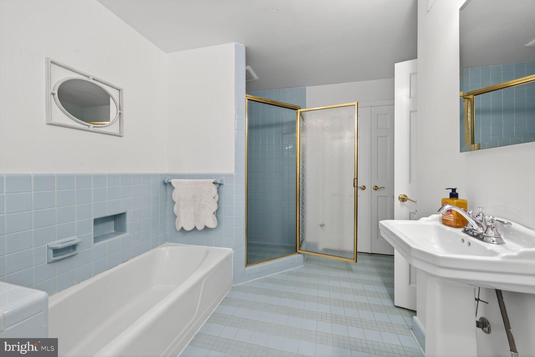 7200 Helmsdale Road Bethesda, MD 20817 - Photo 34 of 50 a bathroom with a tub sink and mirror