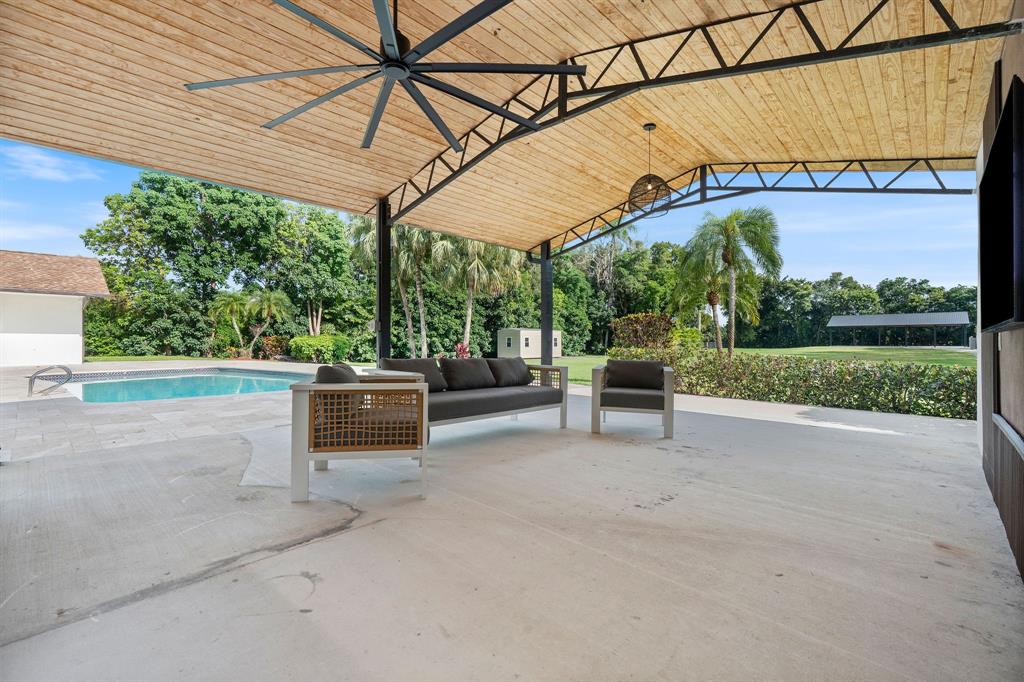 13900 Mustang Trail Southwest Ranches, FL 33330 - Photo 56 of 68 a view of a patio with a table and chairs under an umbrella