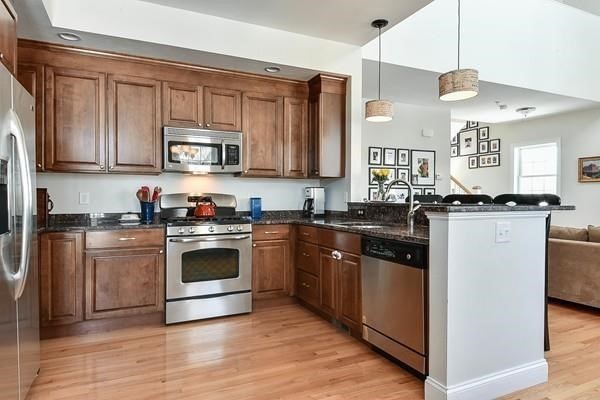 797 Highland Avenue, Unit 4 Needham, MA 02494 - Photo 7 of 21 a kitchen with stainless steel appliances granite countertop a stove a sink and a microwave