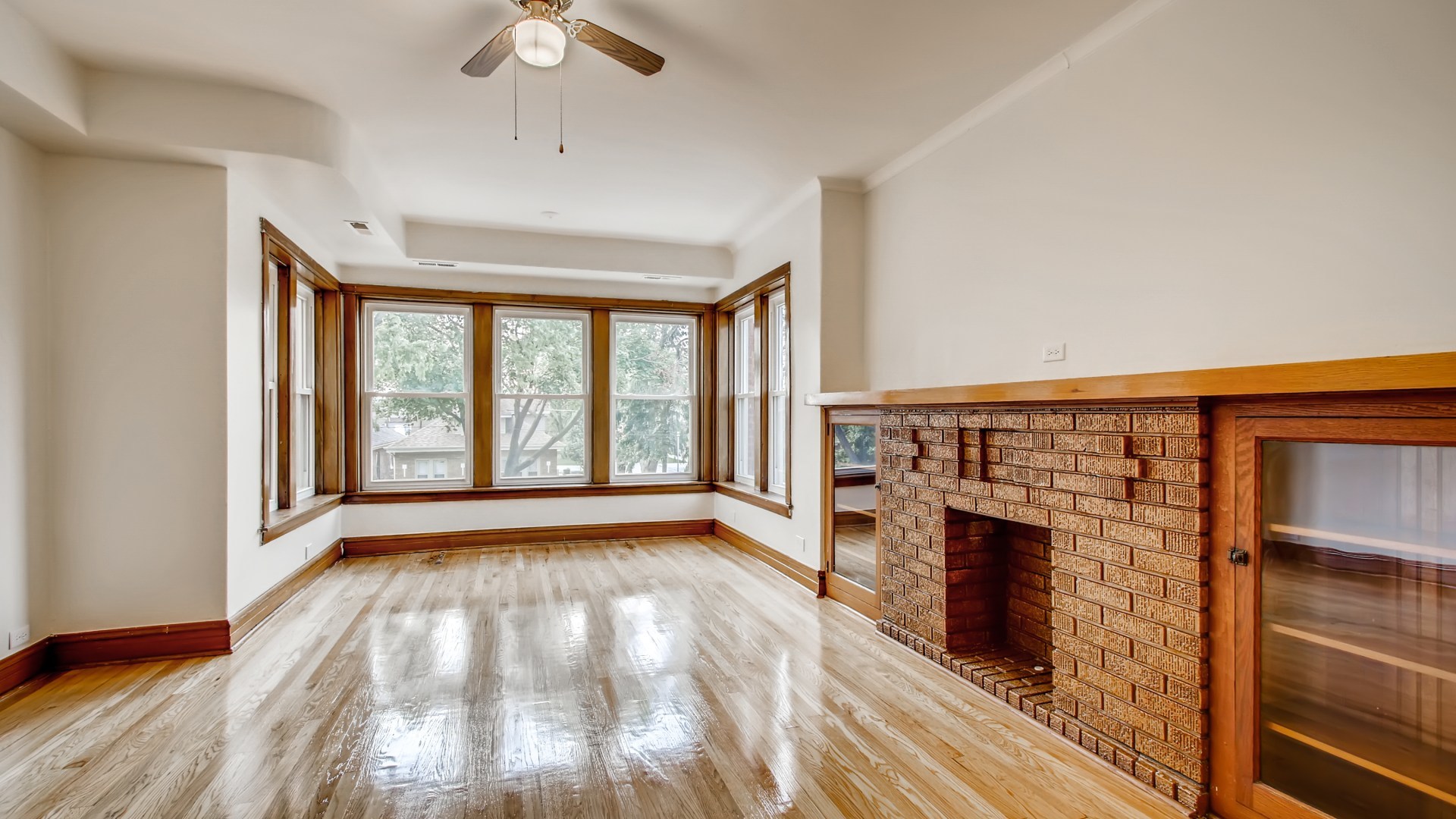 3657 North Lotus Avenue Chicago, IL 60641 - Photo 17 of 29 a view of an empty room with wooden floor fireplace and a window