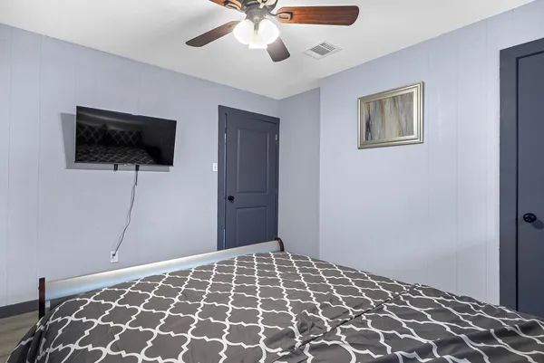 a bedroom with a bed and a flat screen tv