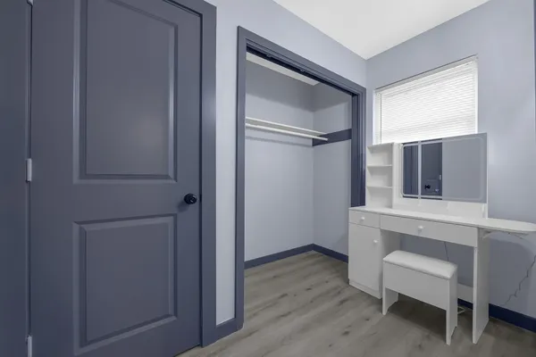 a workspace room with wooden floor cabinet and windows