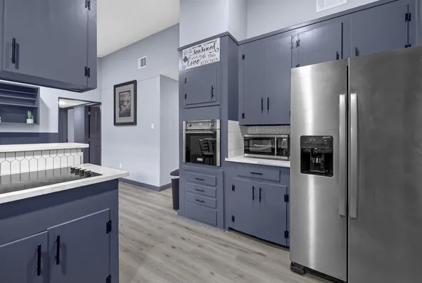 a kitchen with stainless steel appliances granite countertop a refrigerator and a stove top oven