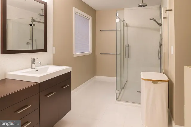 a bathroom with a sink mirror and shower