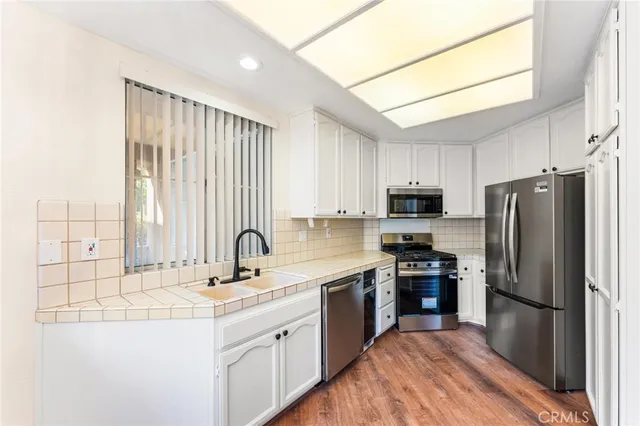 a kitchen with kitchen island granite countertop a sink stainless steel appliances and cabinets