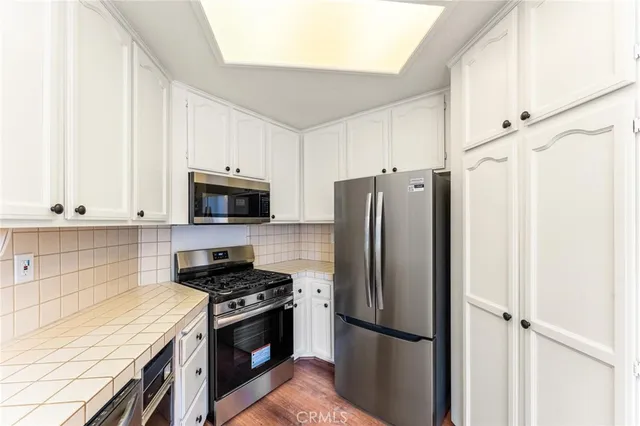 a kitchen with stainless steel appliances a refrigerator stove and microwave