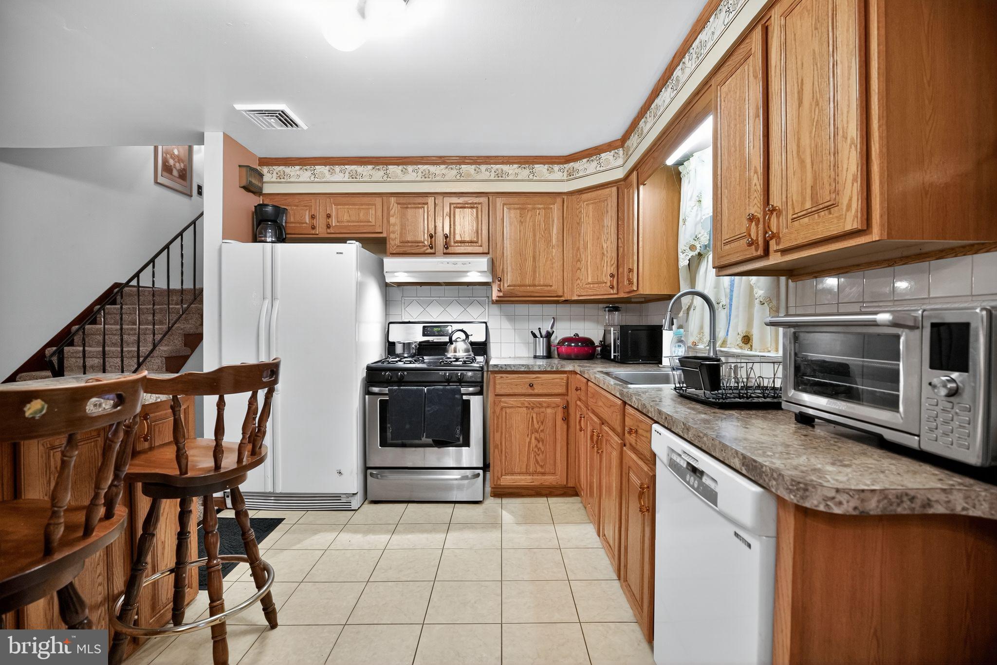 908 Pershing Road Blue Bell, PA 19422 - Photo 15 of 24 a kitchen with stainless steel appliances granite countertop a stove a sink and a microwave