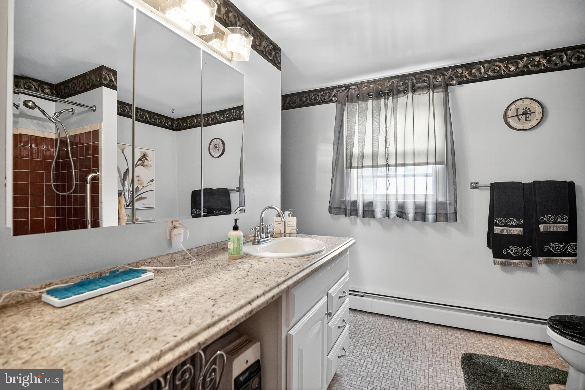 908 Pershing Road Blue Bell, PA 19422 - Photo 19 of 24 a bathroom with a granite countertop sink a mirror and a bathtub