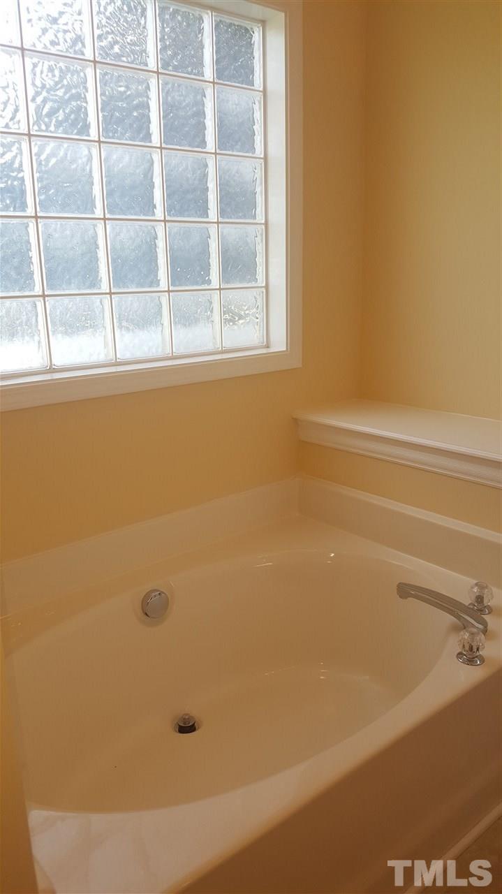 668 Slate Top House Road Clayton, NC 27520 - Photo 22 of 27 Garden Tub with Glass Block wall, allows plenty of light to infiltrate the Master Bath.