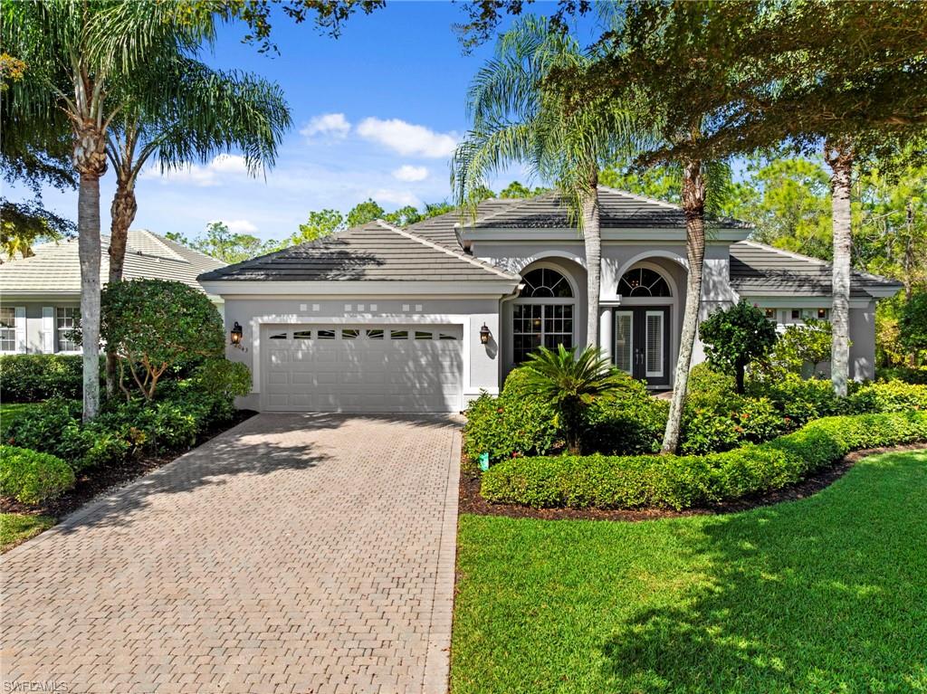 22043 Sycamore Grove Estero, FL 34135 - Photo 1 of 44 a front view of a house with a garden