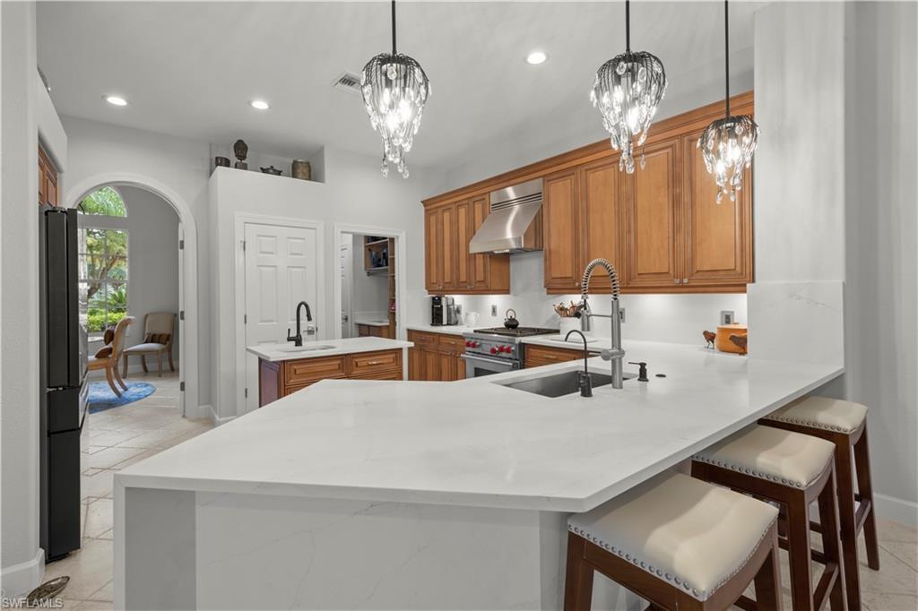 22043 Sycamore Grove Estero, FL 34135 - Photo 13 of 44 a kitchen with stainless steel appliances a table chairs and chandelier