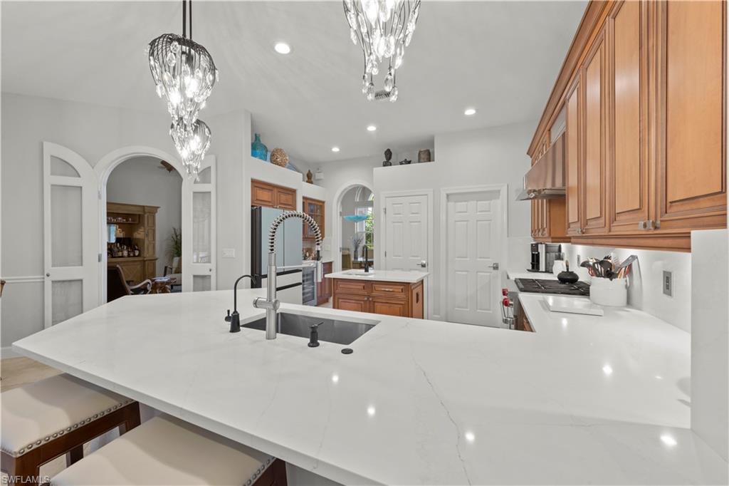 22043 Sycamore Grove Estero, FL 34135 - Photo 16 of 44 a large white kitchen with a large island oven a stove and refrigerator