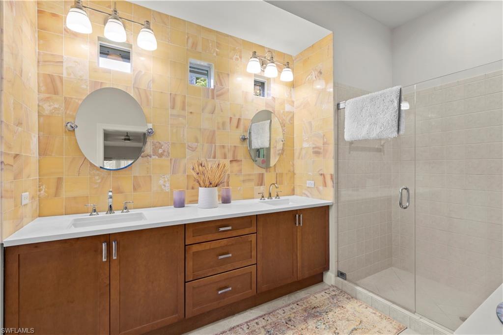 22043 Sycamore Grove Estero, FL 34135 - Photo 29 of 44 a bathroom with a double vanity sink mirror and shower