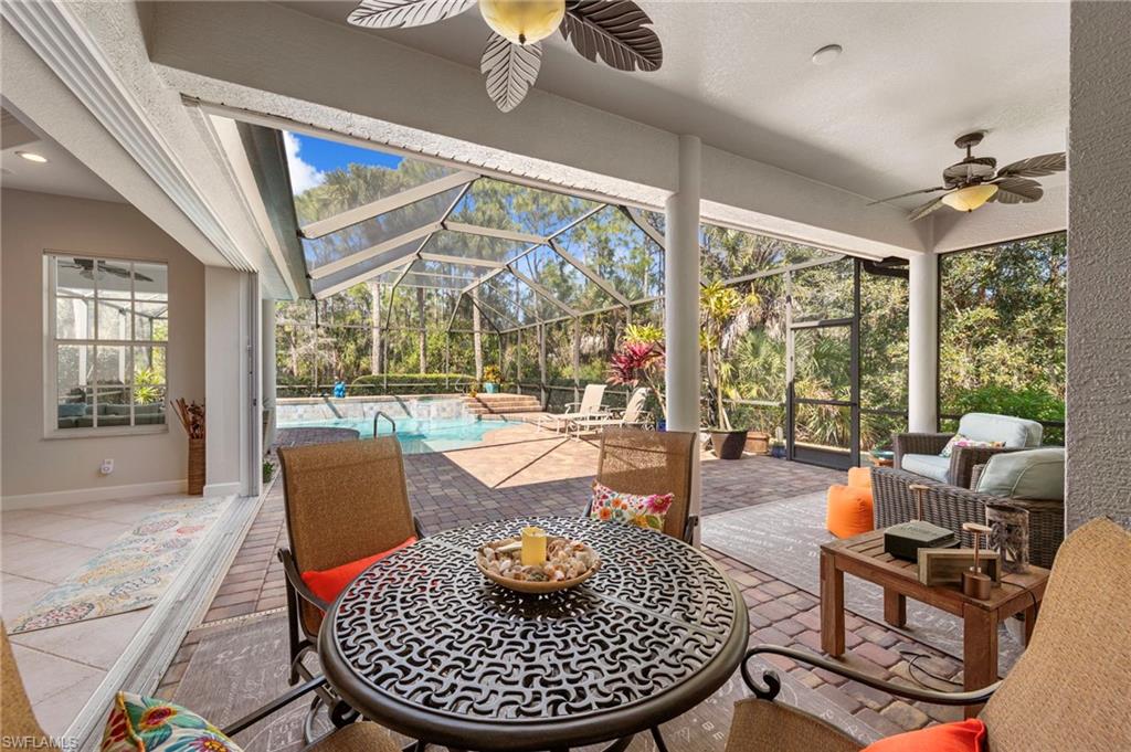 22043 Sycamore Grove Estero, FL 34135 - Photo 32 of 44 a living room with patio fireplace furniture and a large window