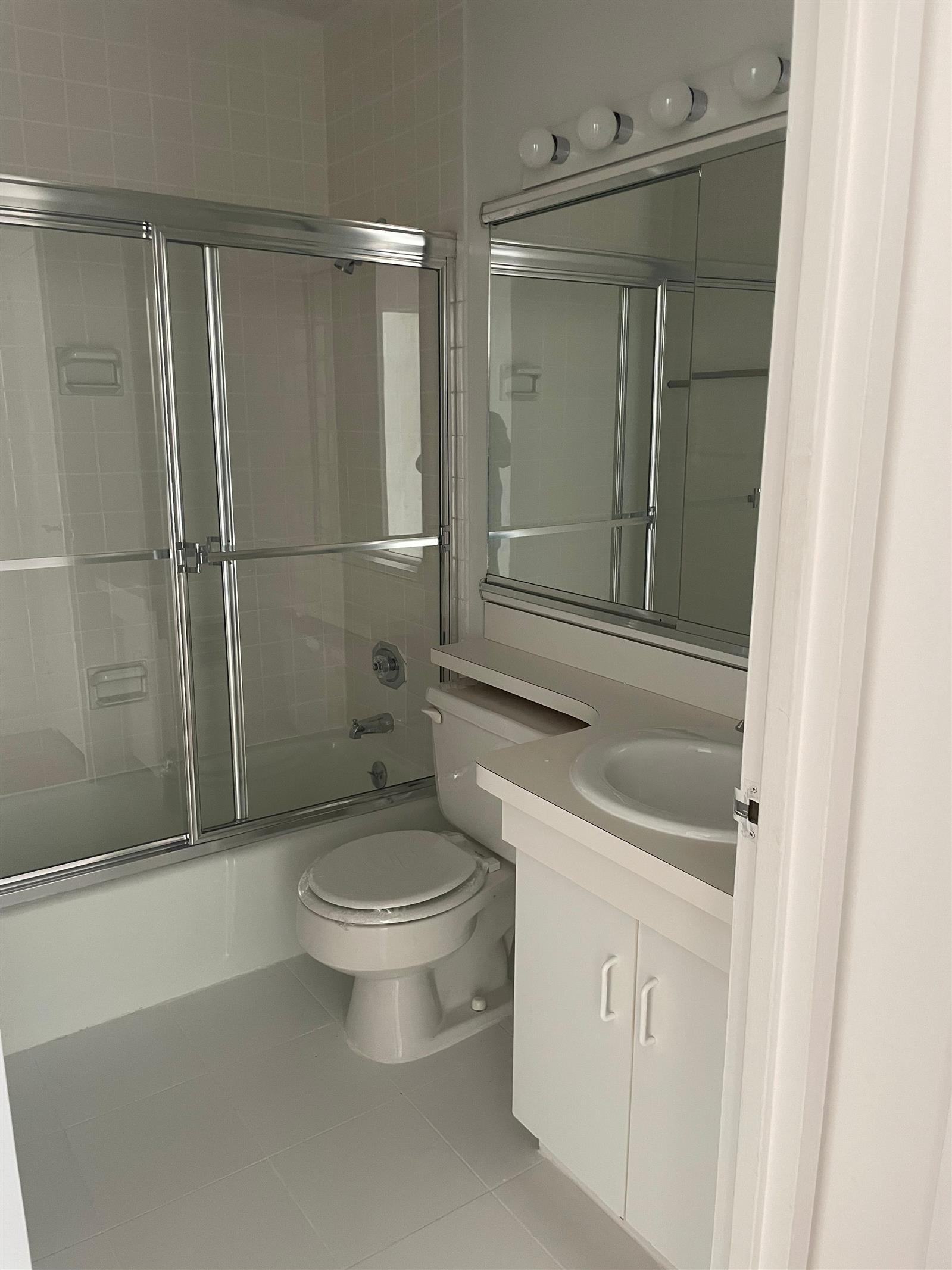 200 East 72nd Street, Unit 22D Manhattan, NY 10021 - Photo 4 of 10 a bathroom with a toilet a sink and shower