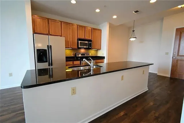 a kitchen with stainless steel appliances a refrigerator sink and microwave
