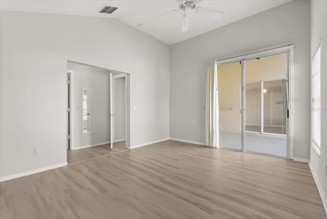 an empty room with wooden floor and mirror