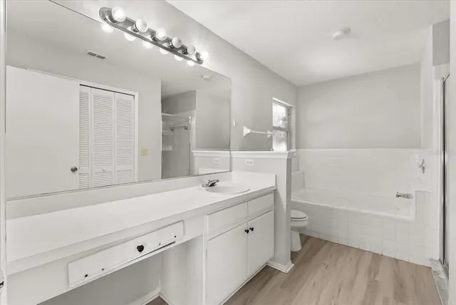 a bathroom with a double vanity sink a mirror and a bathtub