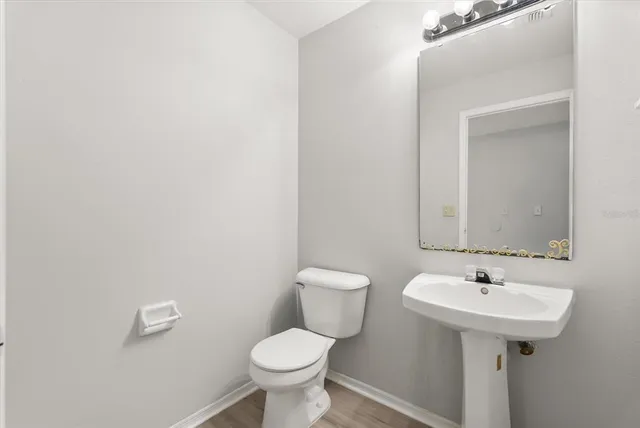 a bathroom with a sink toilet and a mirror