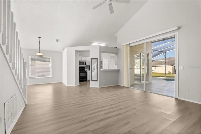 a view of an empty room with window and wooden floor