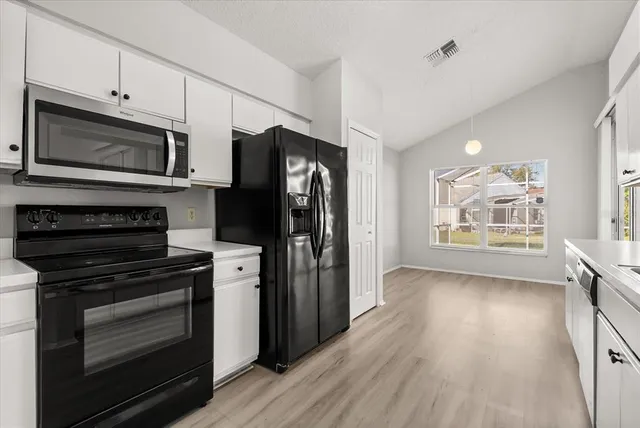 a kitchen with stainless steel appliances a stove microwave and refrigerator