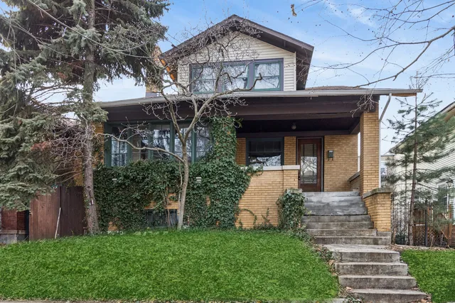 a view of a house with brick walls and a yard with plants