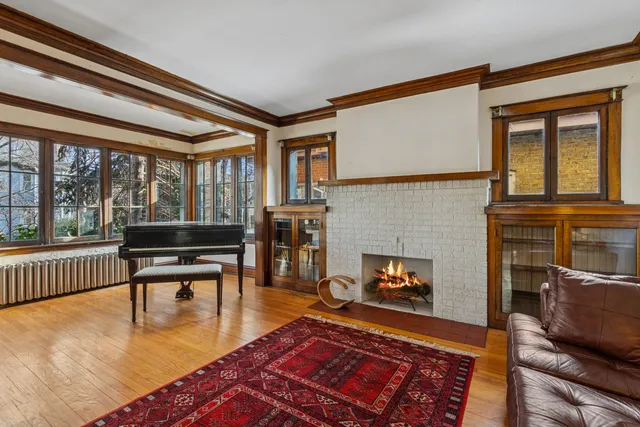 a living room with furniture a fireplace and a floor to ceiling window