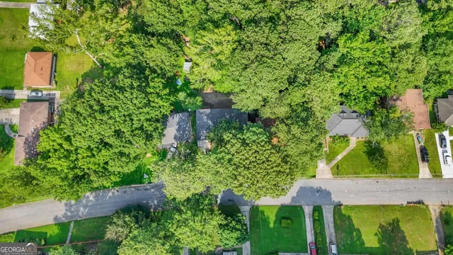 an aerial view of residential house with outdoor space and trees all around