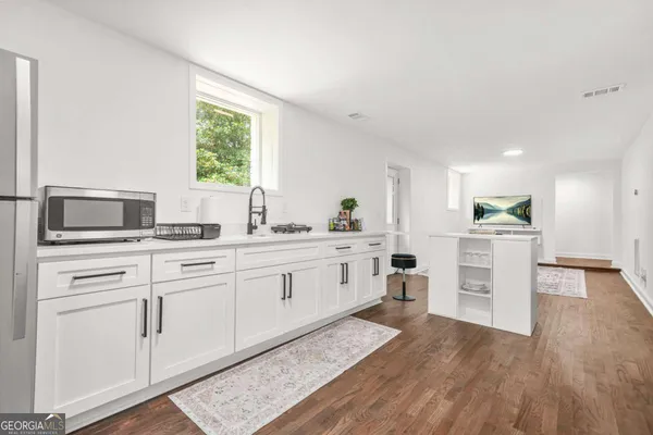 a kitchen with white cabinets and appliances